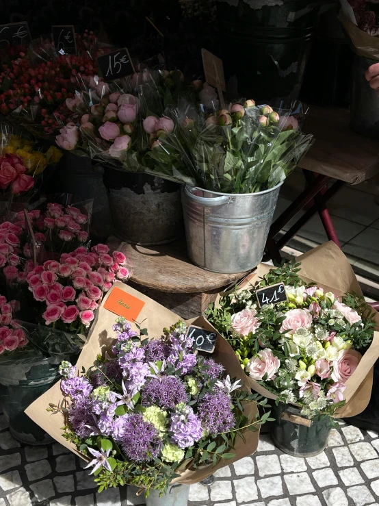 several buckets filled with flowers sitting on a table