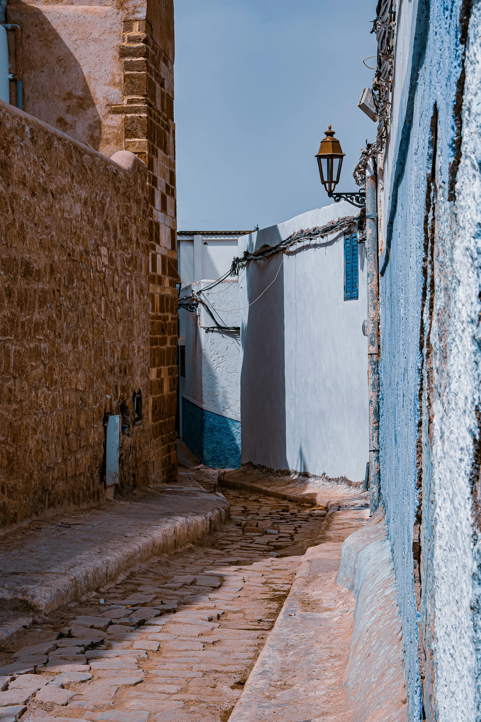 a small alleyway that has a street lamp on the side