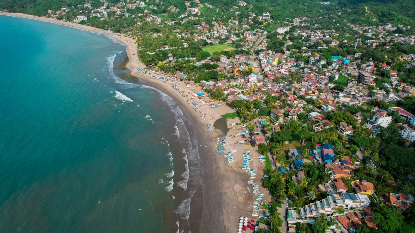 an aerial view of a town, beach and water