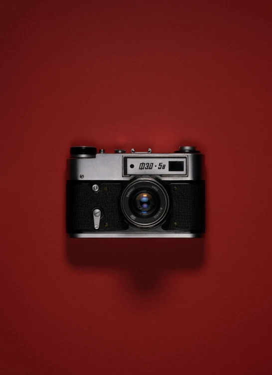 a red background with a black and silver camera