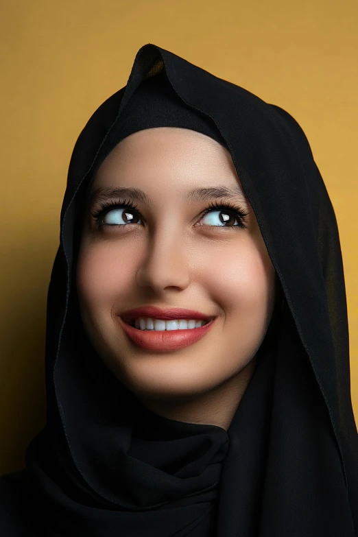 a woman in a hijab smiles for the camera