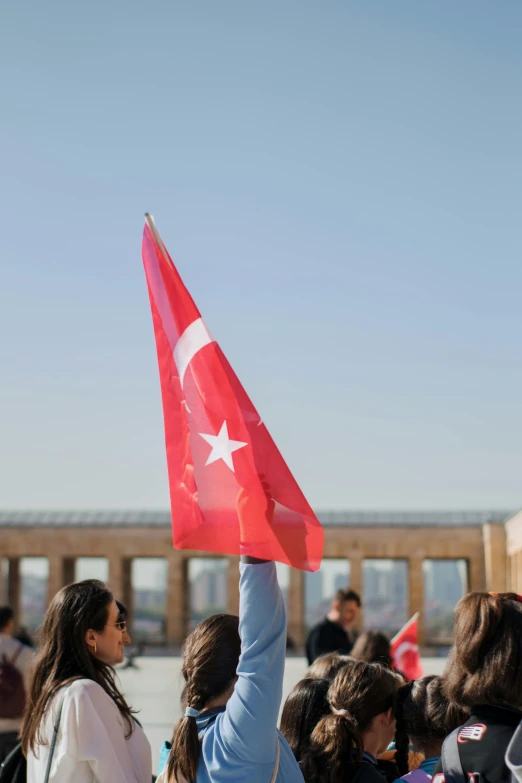 a crowd of people are holding up a flag