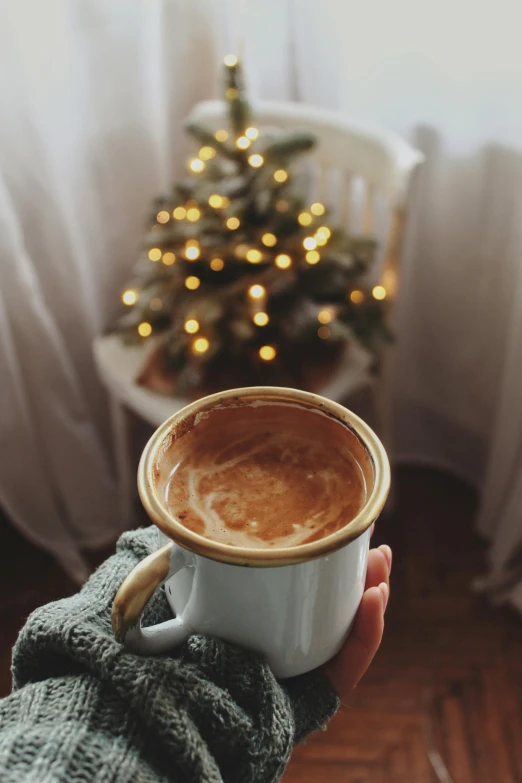 person holding up a cup of coffee