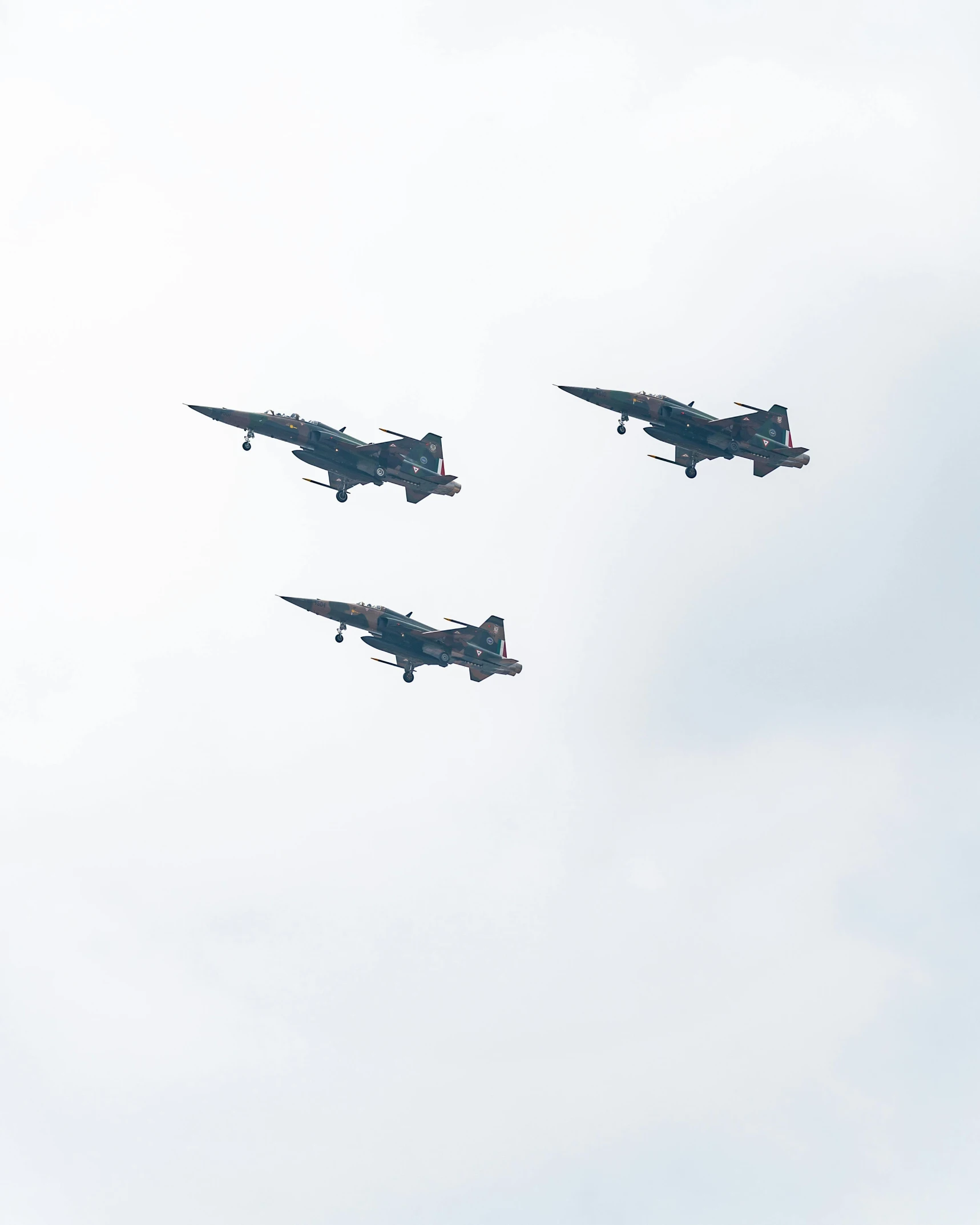 four fighter jets flying in formation in the sky