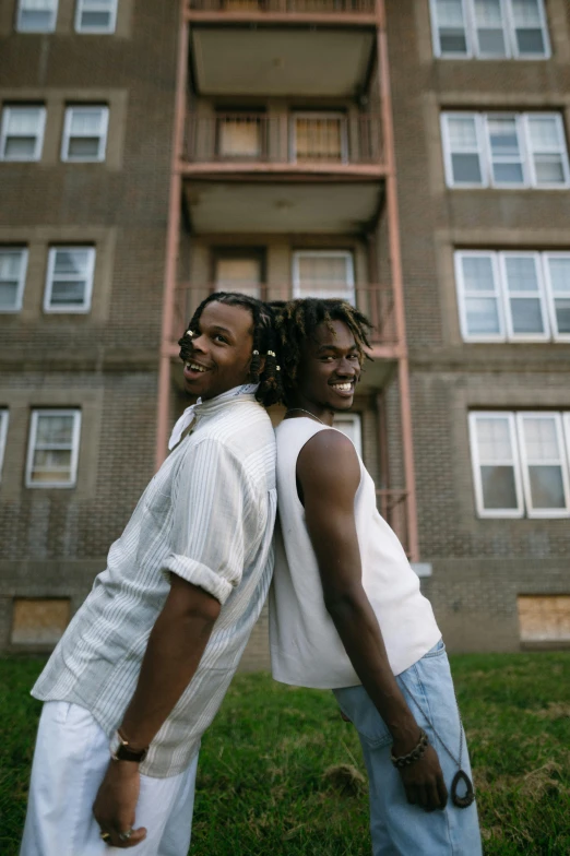 two people are outside of a high - rise apartment building