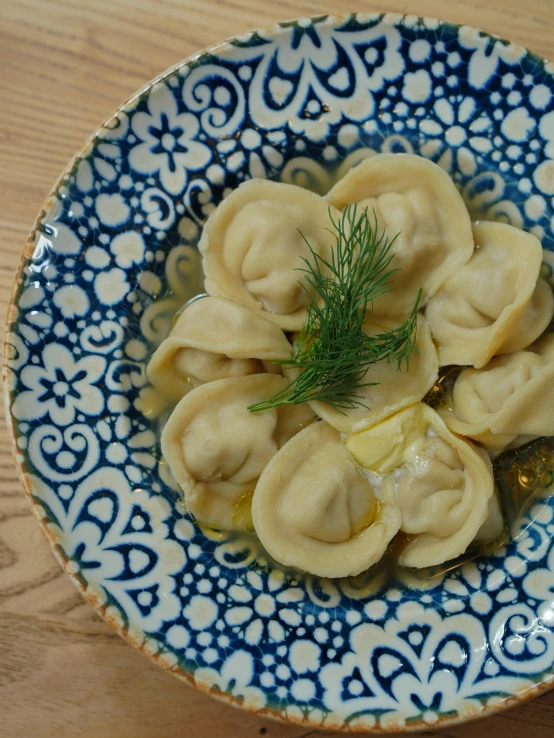 an oriental bowl is full of dumplings covered in sauce