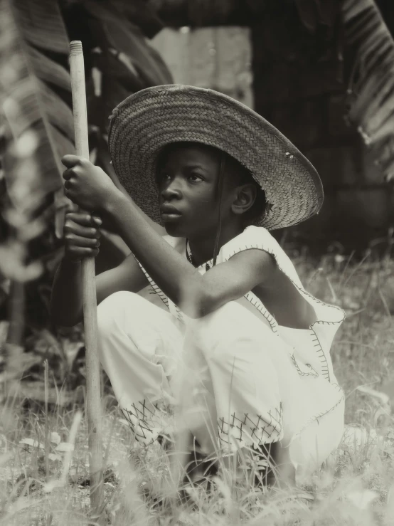 a woman kneeling down in the grass holding a bat