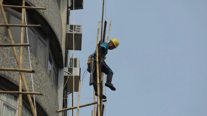 a man on a crane working on an unfinished building