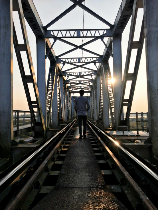a man walks down a bridge towards the camera