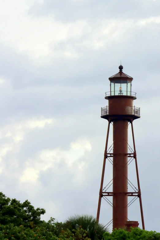 a view of a brown lighthouse with the blue sky in the background