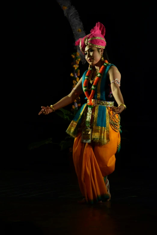 a woman in colorful attire performing an indian dance