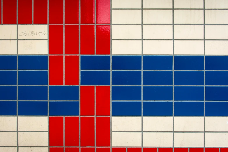 the wall has different red, white, and blue tiles