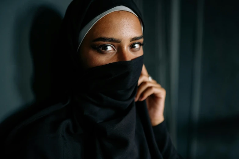 woman wearing a hijab and peeking to the side