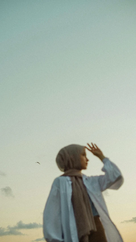 a woman looks up to catch the kite in a field