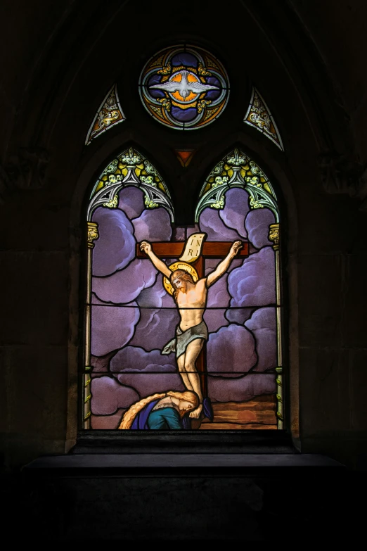 a stained glass window depicting a man on the cross