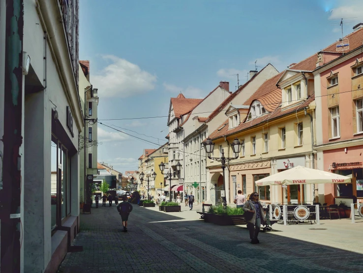 people walking down a cobblestone street in an old town