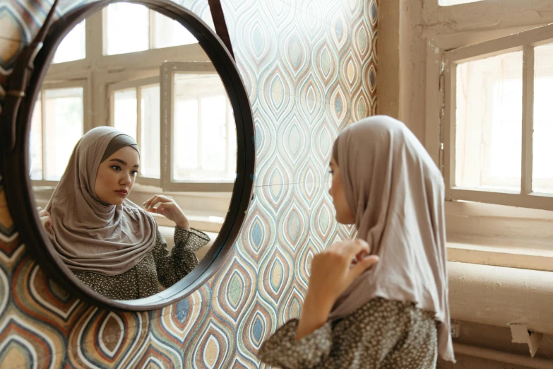 a woman standing in front of a mirror