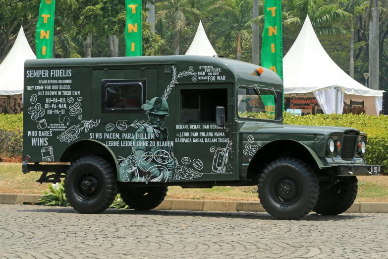 an old green army truck painted with graffiti