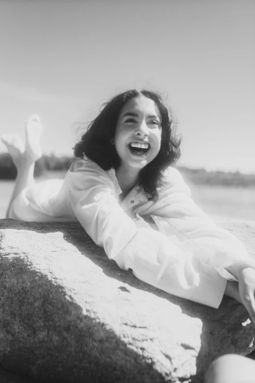 a smiling  lies on rocks in the sun