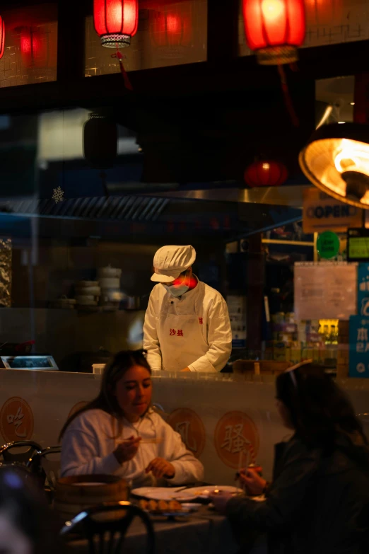 a person sitting at a table behind a counter