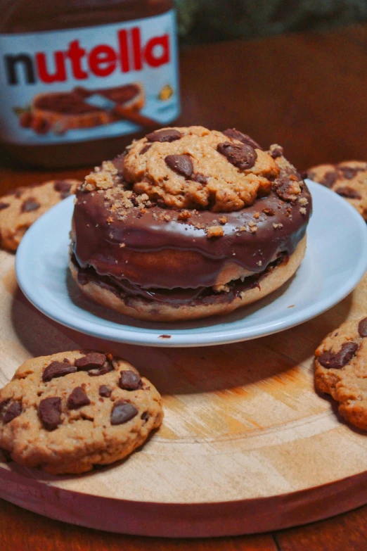 chocolate covered cookies, peanut er and a jar of nutella are on a serving tray