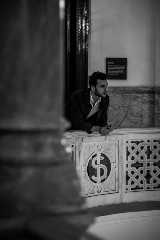 a man sitting on top of a pillar in a building