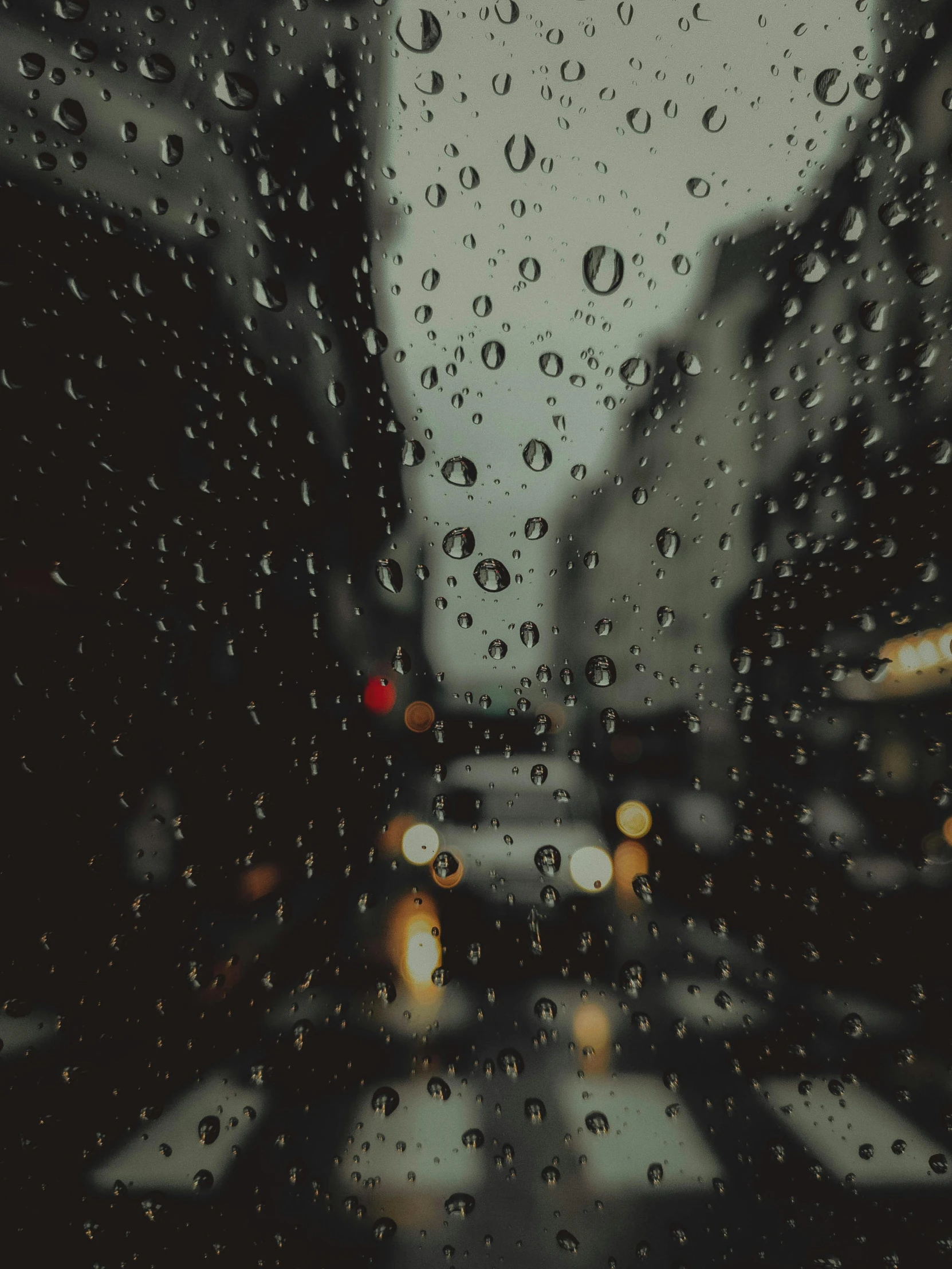 view through a window on cars with rain drops on it