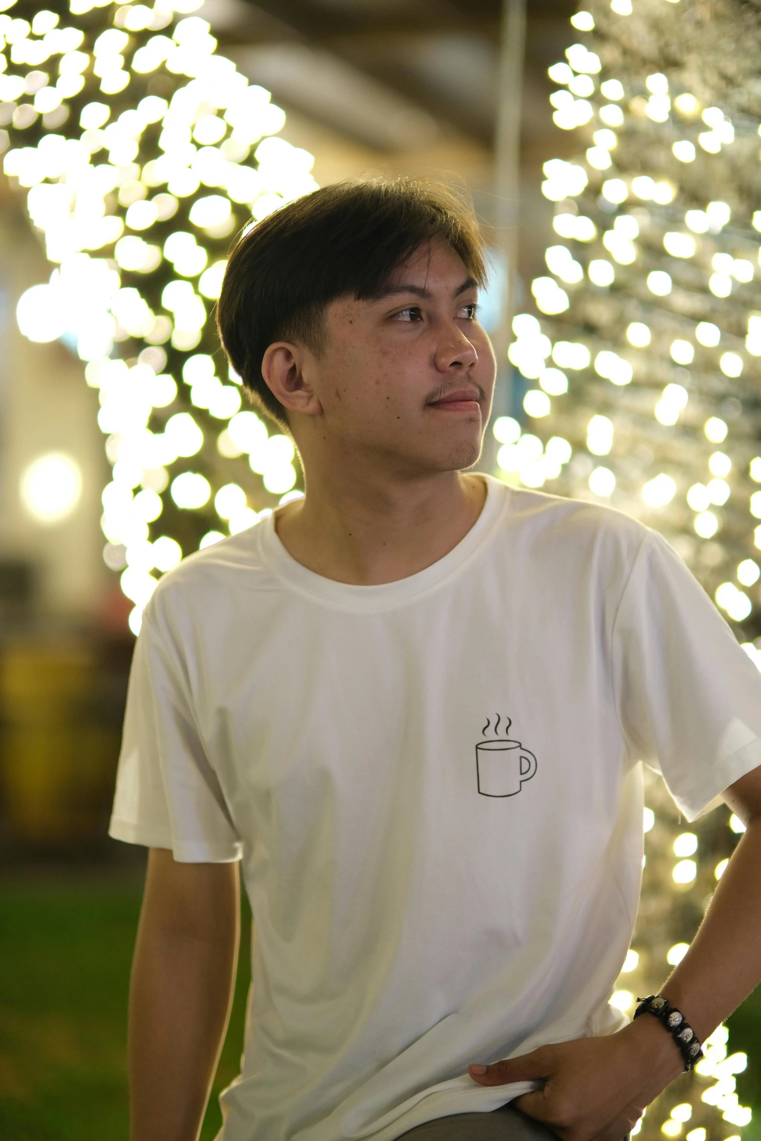 man with a white t shirt and light display in background