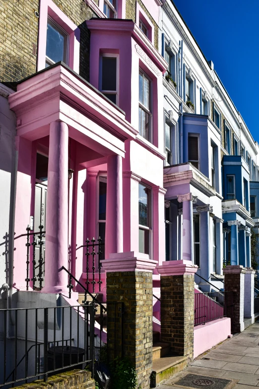 several colorful homes with iron fence on street