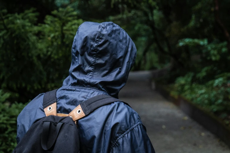 the back view of someone with a backpack walking down the road