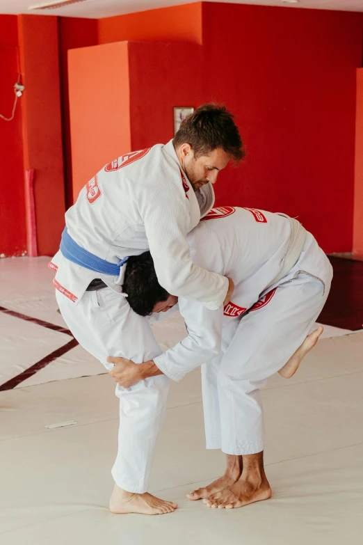 a man in a white uniform is holding another man