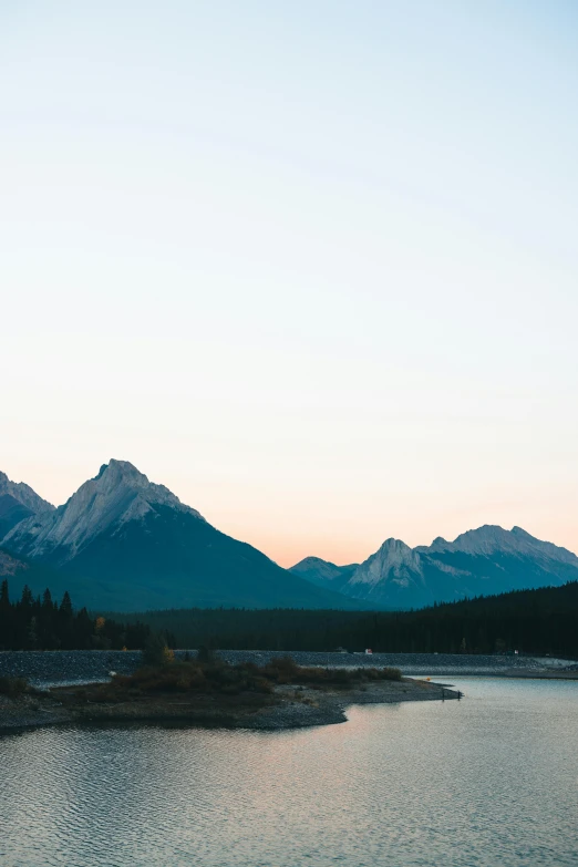 the view of mountains along a river near a field