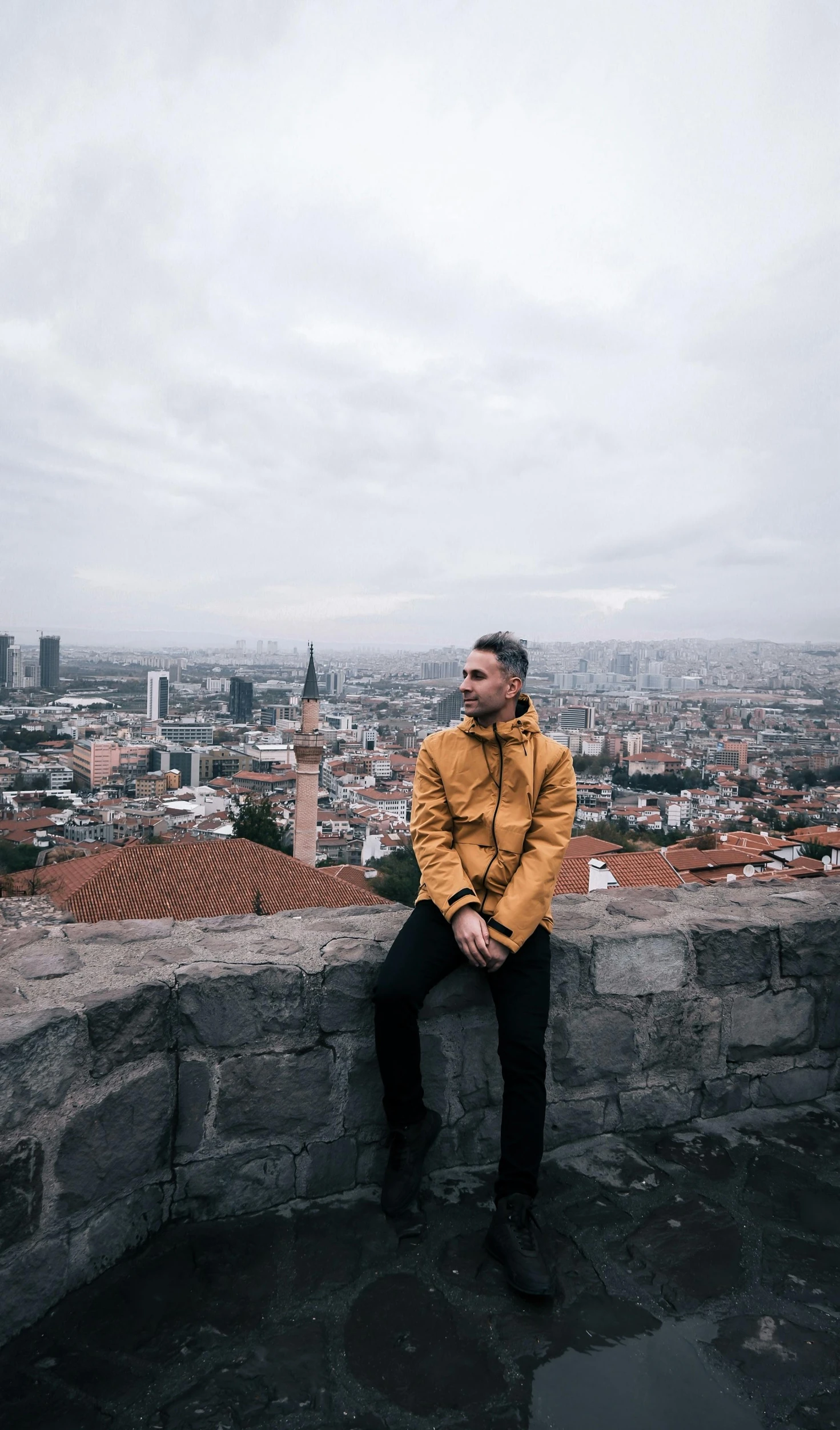 the man is sitting on top of a very tall building