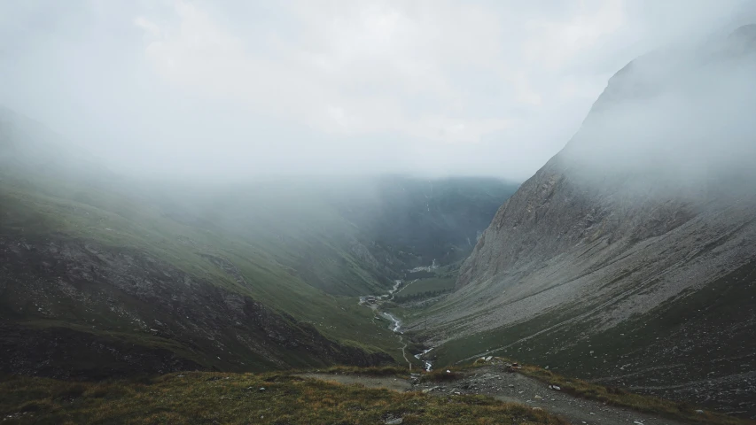 a mountain valley with lots of fog and water