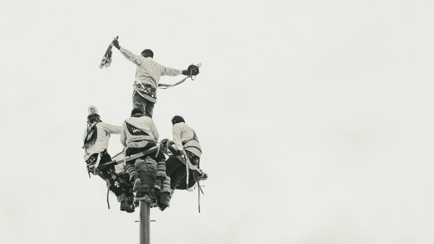 three snowboarders in white jackets and black gloves doing tricks