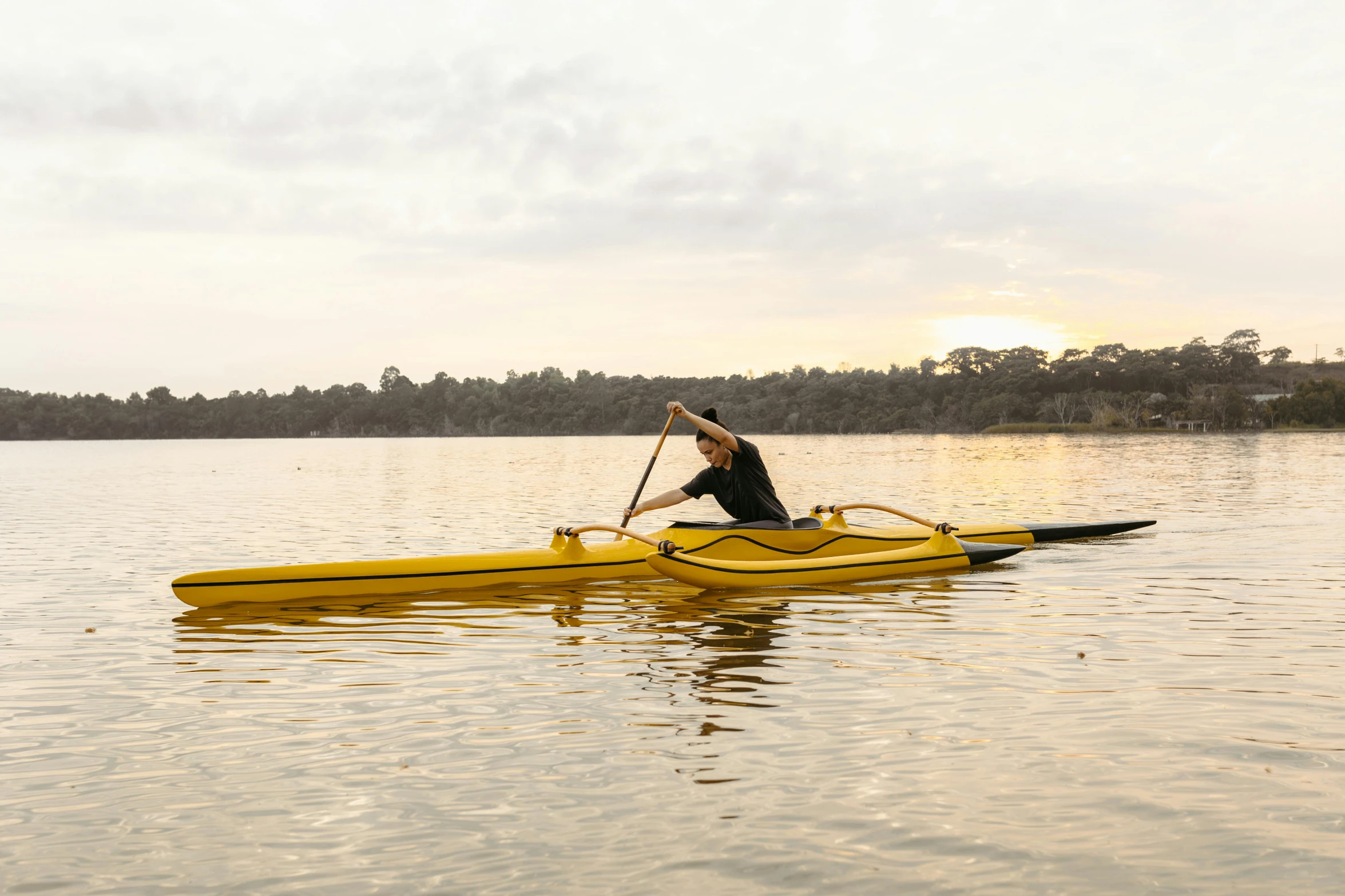 a man is paddling on the lake while holding onto a paddle