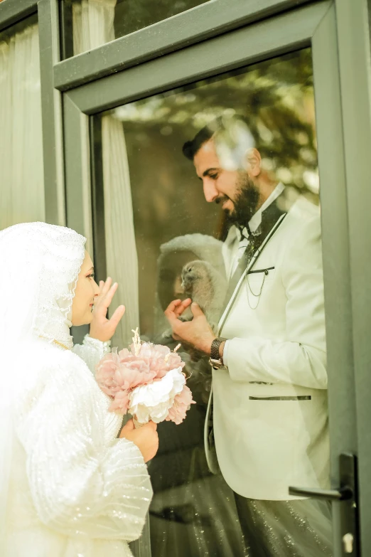 a bride holding a bouquet of flowers and looking at her groom