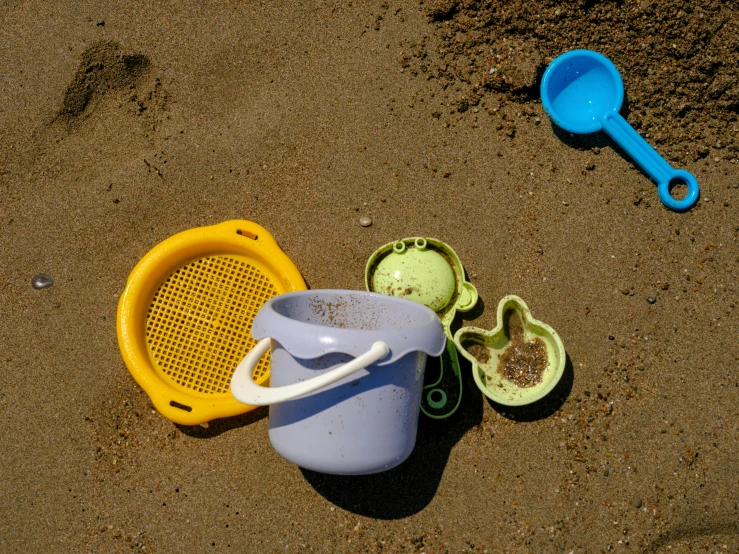 two containers sitting next to each other on a sandy surface