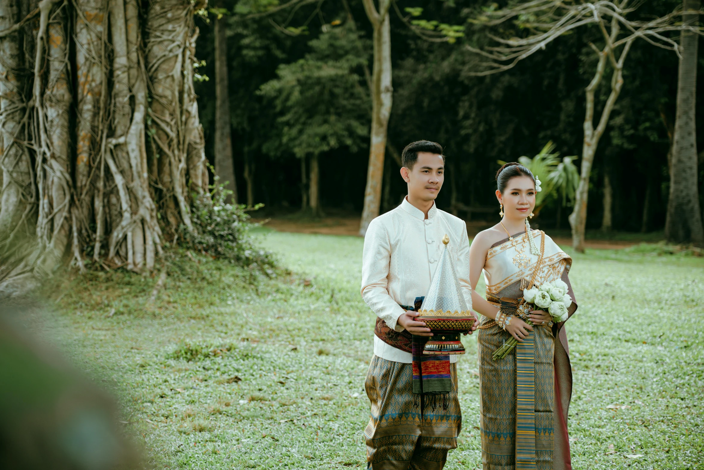 two people stand together with one man wearing a dress and the other holding a plate