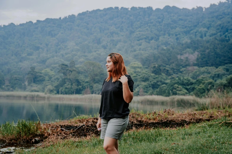 a woman is standing on the edge of a body of water