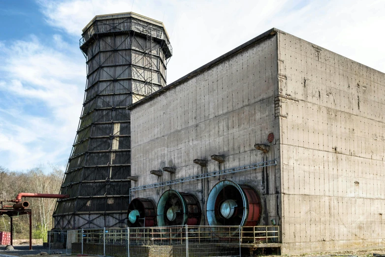 a giant industrial type smokey building with pipework