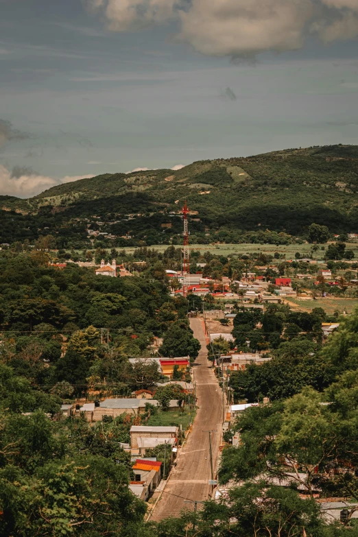 a small village is in the distance among lush green trees