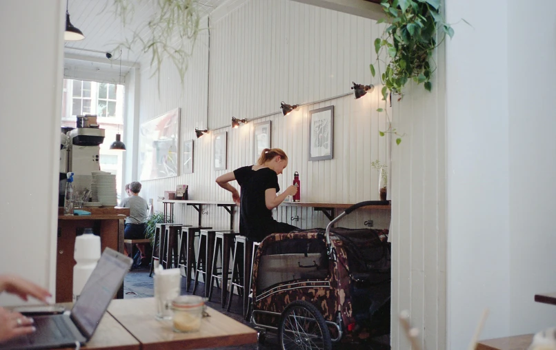 a woman is sitting at the table with her laptop