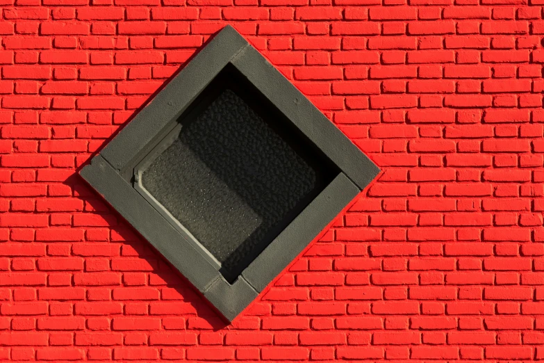 a square speaker on the side of a brick wall