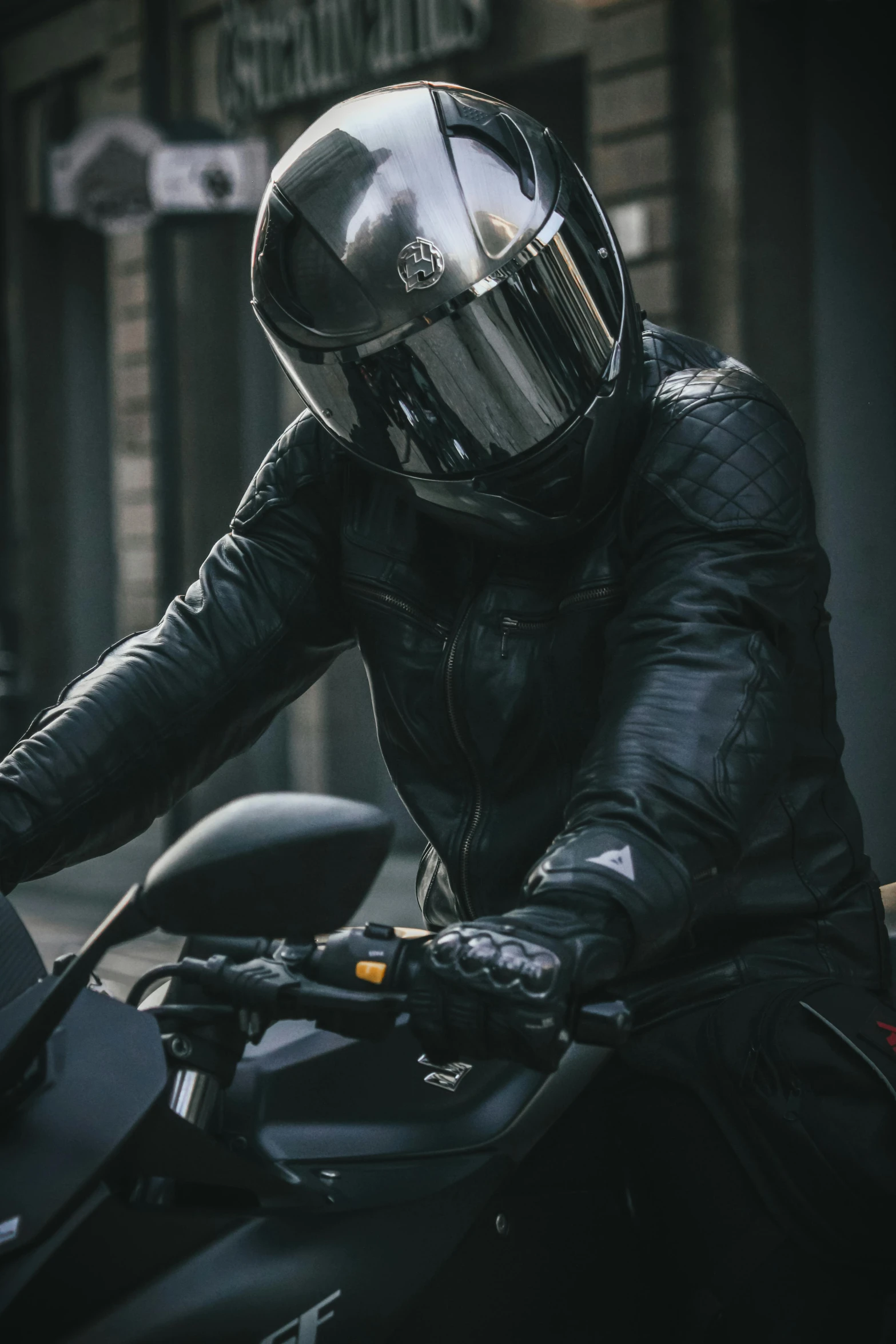 man wearing motorcycle helmet sitting on a black motor bike