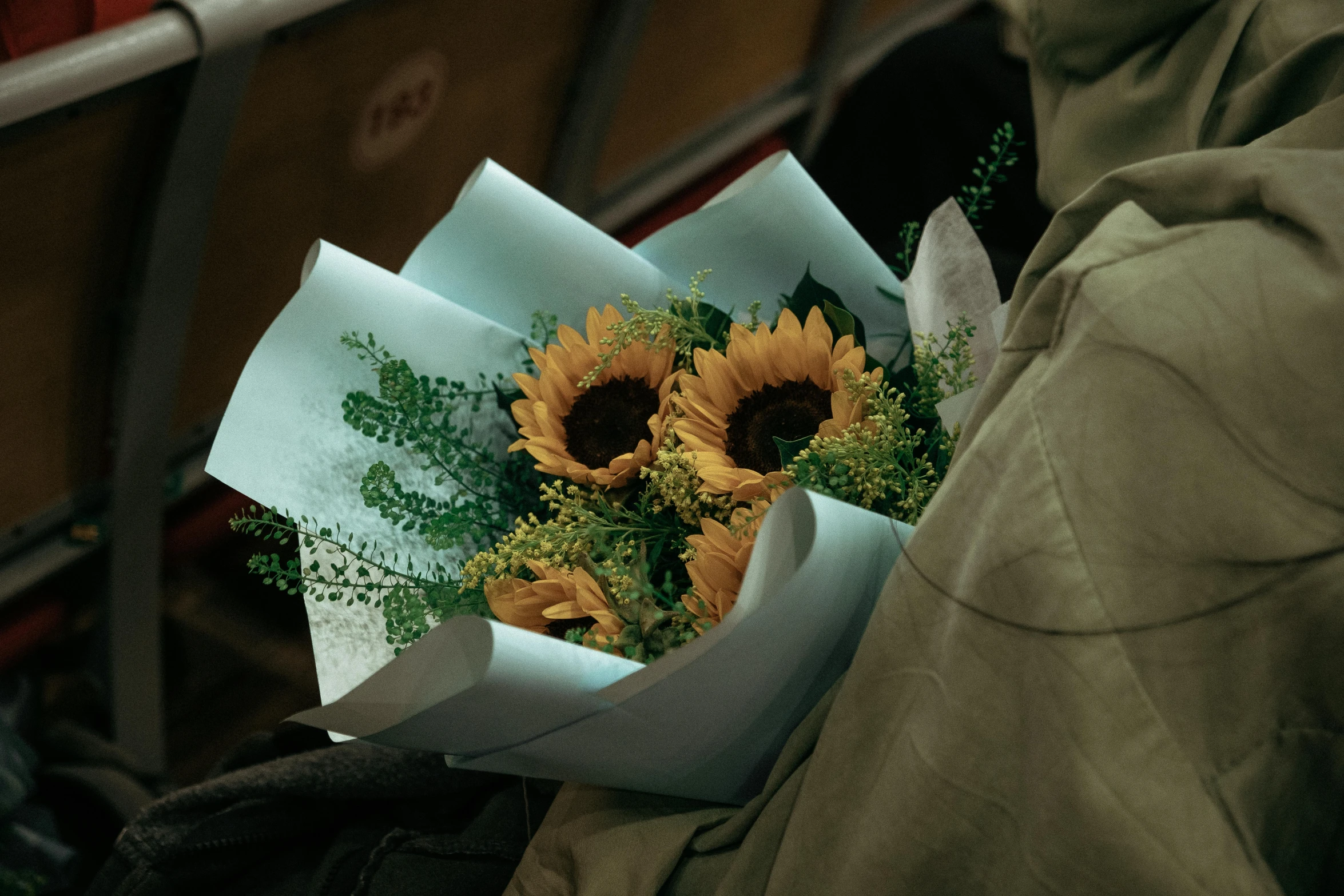 a man is holding a bunch of sunflowers