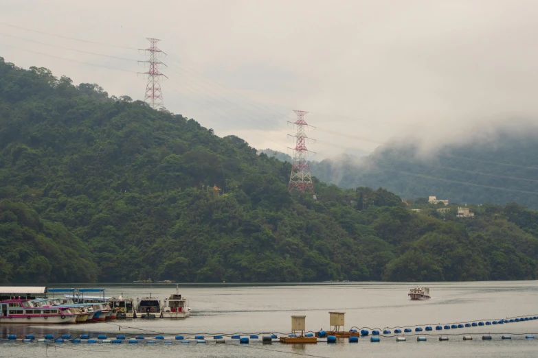 several boats in the water near a hill