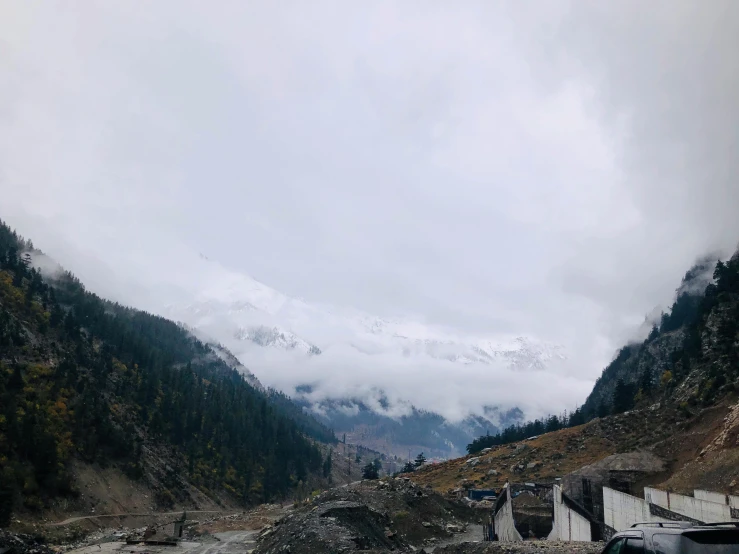 mountains are behind the road and clouds can be seen