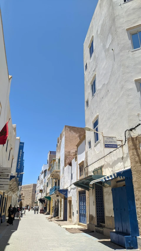 an empty street has blue windows and blue shutters