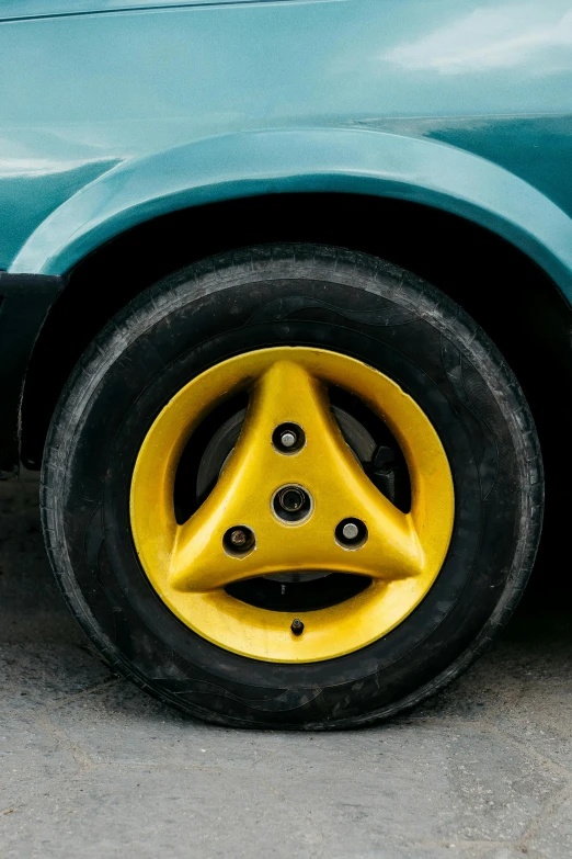 yellow rims and flat tires on a light green car